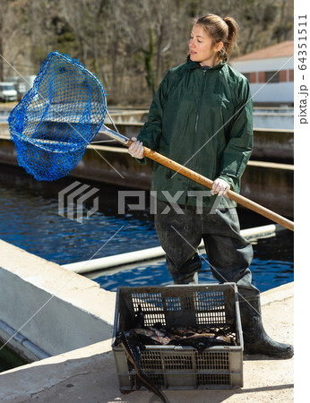 Female farmer posing with landing net Female farmer posing with landing net 64351511