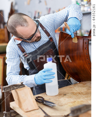 Workman varnishing antique armchair 64352161