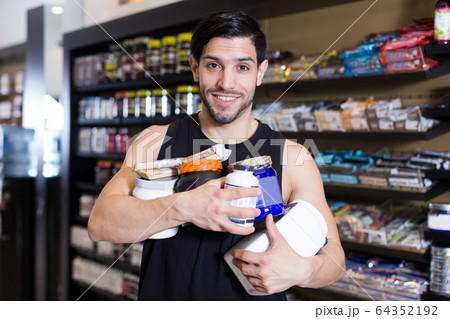 sportman keeping stack of sport products 64352192