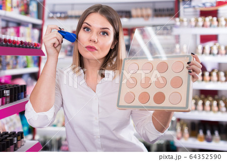Attractive woman testing powder at store Attractive woman testing powder at store 64352590