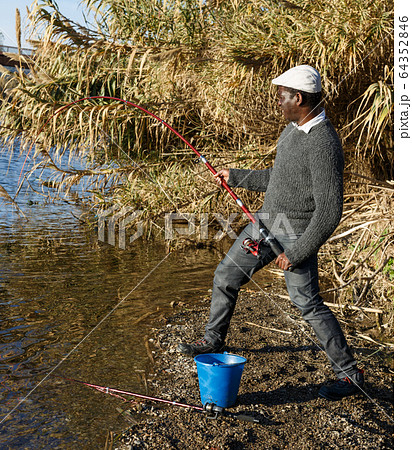 Man and pulling fish near river Man and pulling fish near river 64352846