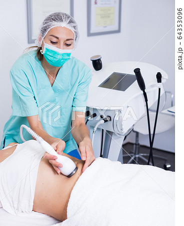 Professional cosmetician performing cryolipolyse 64353096