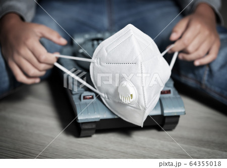 Boy plays with toys coronavirus symbols: toilet paper, medical gloves, protection mask 64355018