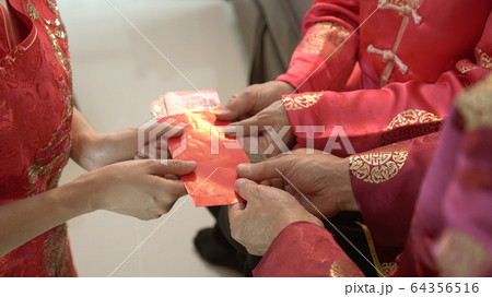 Giving red envelop for Chinese New Year Top view grandparent and five money to children 64356516