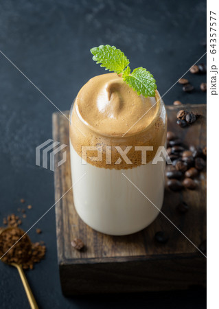 Dalgona frothy coffee in glass on dark. Close up. Dalgona frothy coffee in glass on dark. Close up. 64357577