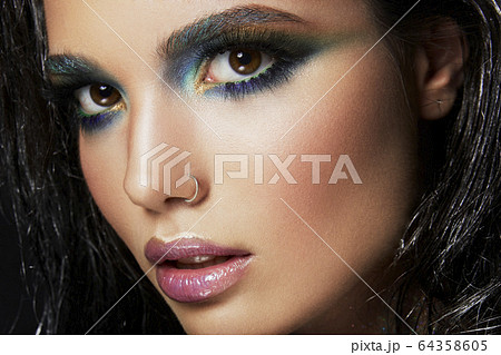 Beautyful girl with blue glitter on her face Beautyful girl with blue glitter on her face 64358605