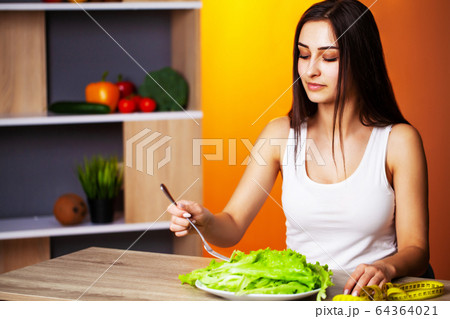 Cute woman with fresh vegetables and fruits leading a healthy lifestyle. 64364021