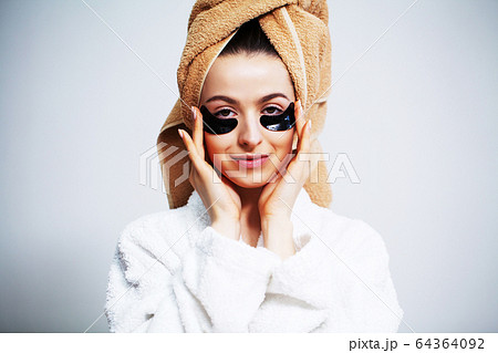 Cute woman in bathroom use patches for facial skin care. 64364092