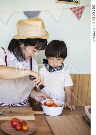 Japanese woman and boy standing in a farm shop, preparing food. 64365569