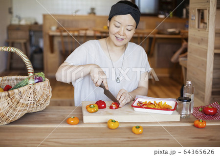 Japanese woman preparing fresh vegetables in a vegetarian cafe. 64365626