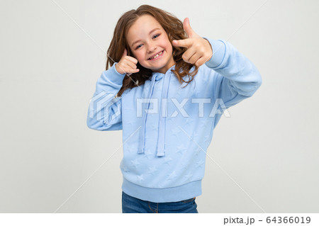 smiling teenage girl in casual blue hoodie shows class on a white background 64366019