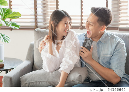 Asian couple lovers enjoy listening streaming online music via smartphone at home 64366642