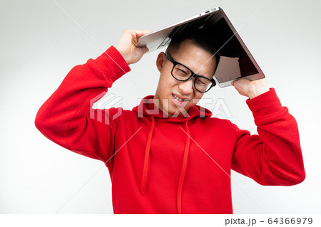man in glasses covered his head with a laptop in the open state on a white studio background man in glasses covered his head with a laptop in the open state on a white studio background 64366979