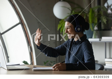 Smiling Indian girl wave talking on video call Smiling Indian girl wave talking on video call 64369309