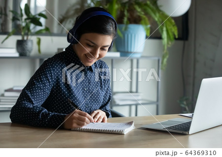 Smiling female in headphones talk on video call Smiling female in headphones talk on video call 64369310