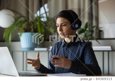 Indian female employee in headset consult client online Indian female employee in headset consult client online 64369313