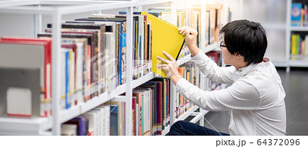 Asian man university student choosing book in 64372096