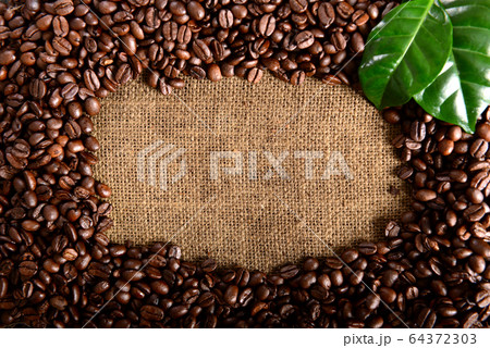 Coffee background with roasted beans and leaves Coffee background with roasted beans and leaves 64372303