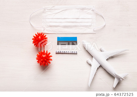 Plane model and face mask and flag Estonia. Coronavirus pandemic. Flight ban and closed borders for tourists and travelers with coronavirus covid-19 from Europe and Asia. Plane model and face mask and flag Estonia. Coronavirus pandemic. Flight ban and closed borders for tourists and travelers with coronavirus covid-19 from Europe and Asia. 64372525