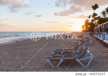 Sunloungers are on sandy beach at sunrise Sunloungers are on sandy beach at sunrise 64373257