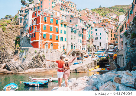 Young tourist couple traveling on european holidays outdoors in italian vacation in Cinque Terre 64374054