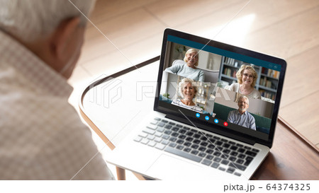 Senior man makes videocall talking with friends by videoconference application 64374325