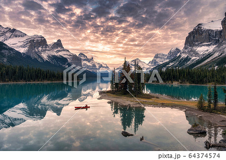 Traveler canoeing with rocky mountain reflection Traveler canoeing with rocky mountain reflection 64374574