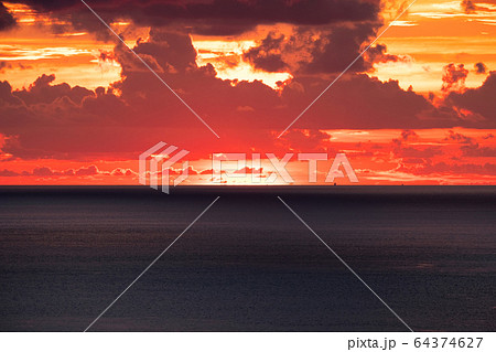 Sunset goes down over horizon in tropical sea with 64374627