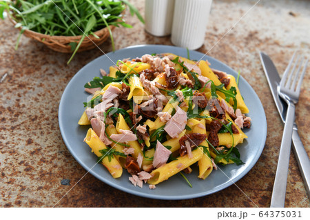 Penne pasta with tuna chunks, rucola and dry 64375031