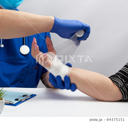 doctor sits at a table in blue uniform and latex 64375151