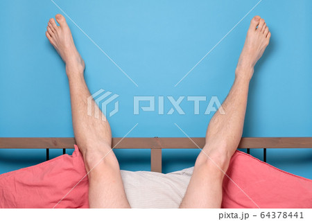 man legs resting in quarantine at bed at home. 64378441