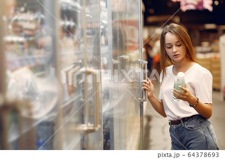 Young woman shoppong in supermarket 64378693