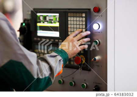 operator programs the CNC manufacturing machine 64383032