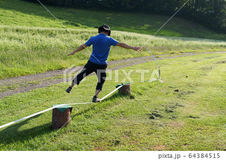 スラックラインをする男性 64384515