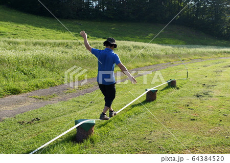 スラックラインをする男性 64384520
