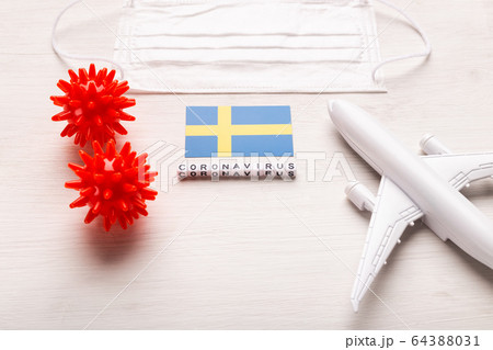 Plane model and face mask and flag Sweden. Coronavirus pandemic. Flight ban and closed borders for tourists and travelers with coronavirus covid-19 from Europe and Asia. Plane model and face mask and flag Sweden. Coronavirus pandemic. Flight ban and closed borders for tourists and travelers with coronavirus covid-19 from Europe and Asia. 64388031