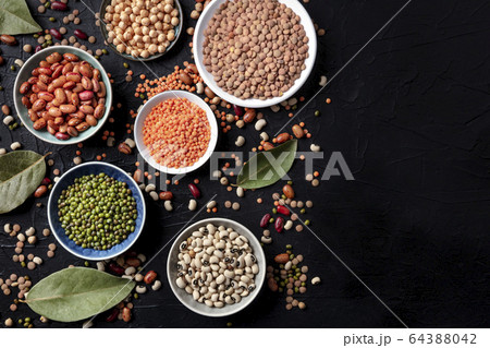 Legumes flatlay assortment, shot from above on a black background with copy space. Lentils, soybeans, chickpeas, red kidney beans, a vatiety of pulses 64388042