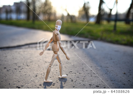 Wooden mannequin with face mask in town, corona virus and lockdown concept. Wooden mannequin with face mask in town, corona virus and lockdown concept. 64388626