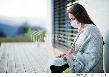 Woman working outdoors at home, Corona virus and quarantine concept. Woman working outdoors at home, Corona virus and quarantine concept. 64388731