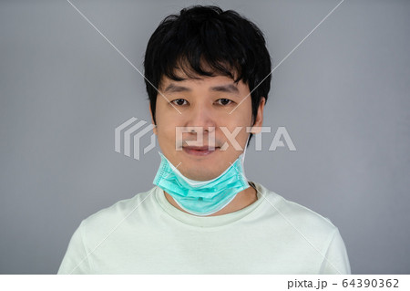 man removes medical mask (surgical mask) and 64390362