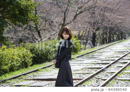 京都府京都市東山区の蹴上インクラインで桜を背景にしている若い女性 64390540