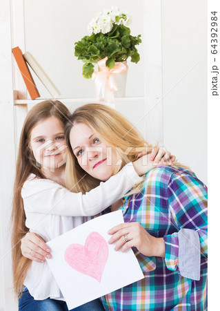 Mother's Day, holidays and family holidays - Mother holds greeting card from her lovely daughter. 64392984