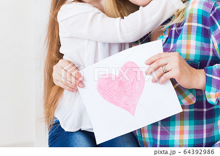 Mother's Day, holidays and family holidays - Mother holds greeting card from her lovely daughter, close-up. 64392986