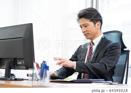 オフィスでデスクワークをするミドルエイジのビジネスマン 64393028