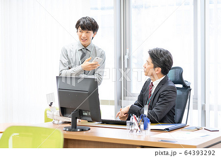 オフィスで話をする部長と部下 64393292