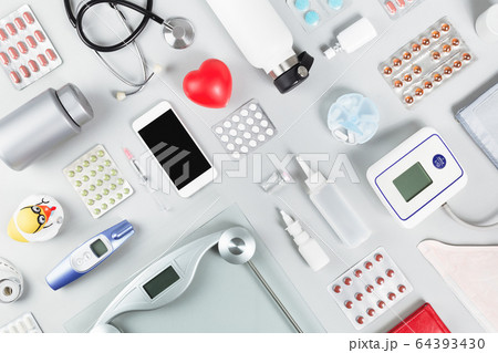 Red heart with phonendoscope scales and  tablets. 64393430