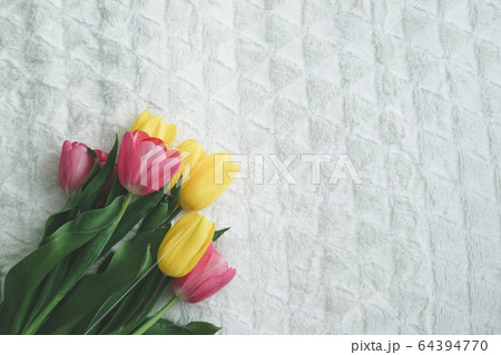 Bouquet of tulips on the edge of the bed, top view Bouquet of tulips on the edge of the bed, top view 64394770