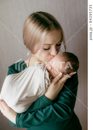 Young beautiful blond hair mamaso with a baby in her arms at home. Happy motherhood 64395735