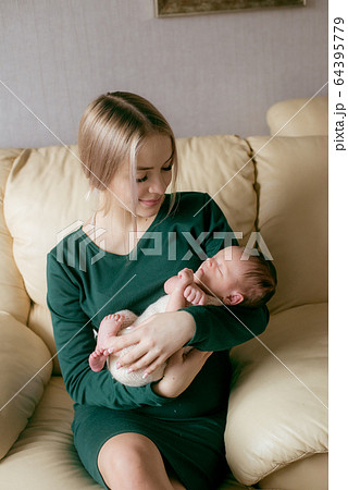 Young beautiful blond hair mamaso with a baby in her arms at home. Happy motherhood 64395779