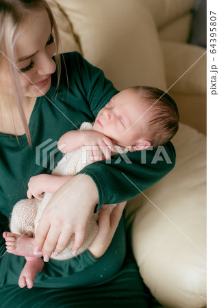 Young beautiful blond hair mamaso with a baby in her arms at home. Happy motherhood 64395807